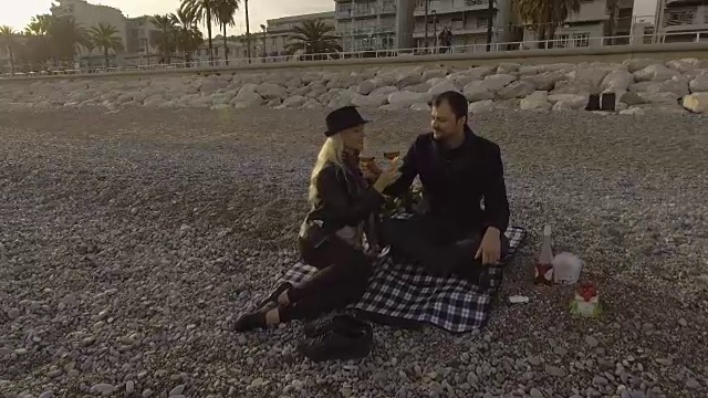 女性和男性在法国里维埃拉海滩上喝葡萄酒兄弟情谊，浪漫视频下载