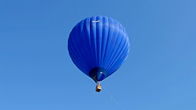 蓝色的热气球在蓝天的背景下飞行视频素材