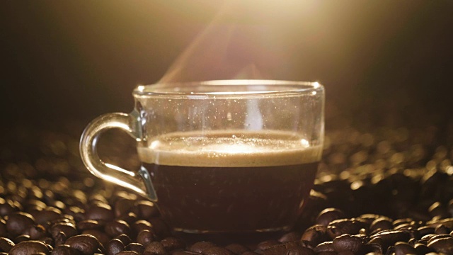 俯视图一杯意大利咖啡在木质背景与咖啡豆被磨碎。上等的咖啡，热气腾腾的。概念:放松、芳香和香水。视频下载