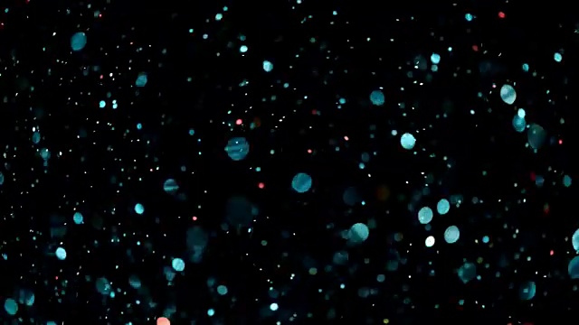 美丽的动画多色飞行闪烁粒子分散在一个黑色的背景视频素材