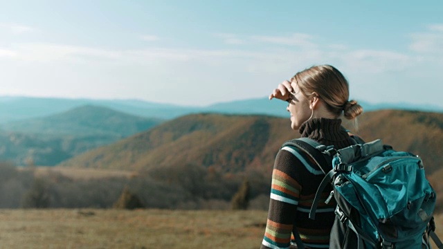 在山顶眺望远方的女徒步旅行者视频下载