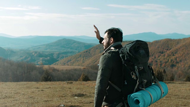 一个在山顶上眺望远方的徒步旅行者视频素材