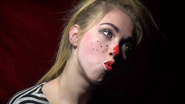 化妆成小丑的漂亮女人快乐地做着鬼脸视频下载