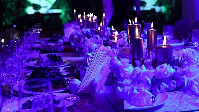 装饰蜡烛在桌子上，眼镜和圣诞蜡烛在桌子上，婚礼装饰，白色蜡烛与玻璃烛台，蜡烛与玻璃烛台，餐厅，室内，特写视频素材