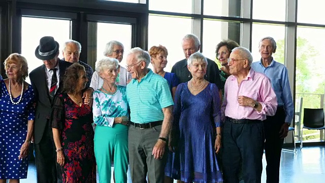 一群微笑的老年人在社区中心跳舞后的照片视频下载