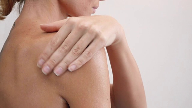 肩部和女性背部身体乳液蔓延缓慢动作特写视频下载