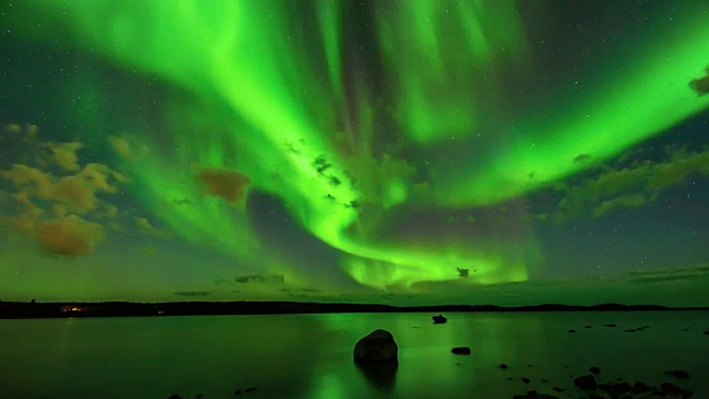 极光波段-一段延时视频的明亮波段的极光光束扫描通过星空在一个北方湖。视频素材
