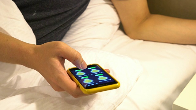 床上拿着手机的女人视频素材