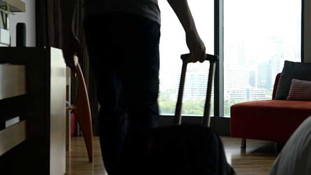 一个男人把手提箱的轮子推进酒店视频下载
