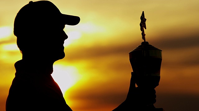 日落剪影赢得职业男性高尔夫球与奖杯视频素材