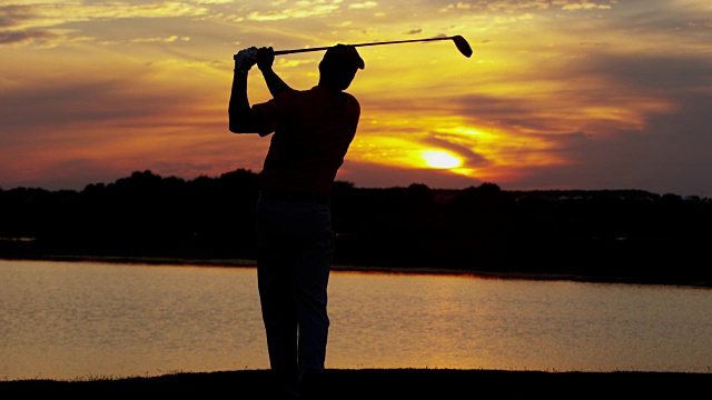 日落剪影男性高尔夫球在球道开球视频素材
