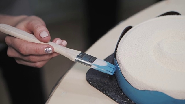 糖果商正在把食用染料的蓝色油漆涂在蛋糕上。一件烹饪艺术作品。慢动作视频素材