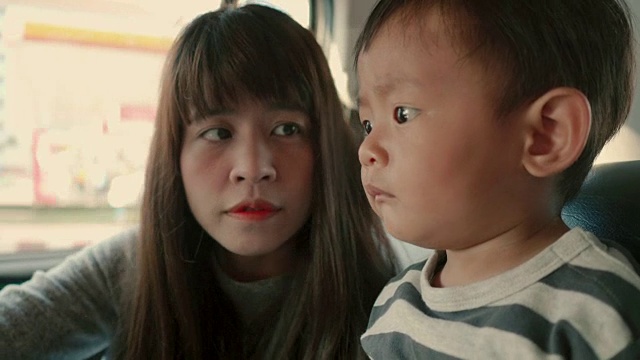 年轻的亚洲母亲带着男婴开车旅行。视频素材
