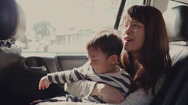 年轻的亚洲母亲带着男婴开车旅行。视频素材