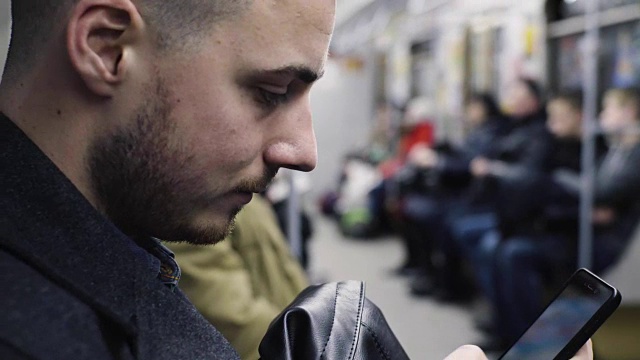 年轻人在乘坐地铁时使用智能手机视频素材