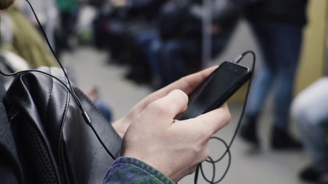 一名年轻人在乘坐地铁时用手机听音乐视频素材