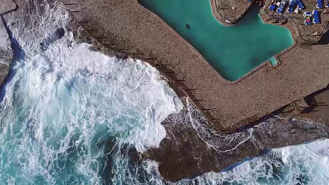飞过黑山的绿色海浪拍打着岩石视频素材