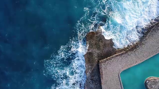 飞过黑山的绿色海浪拍打着岩石视频素材