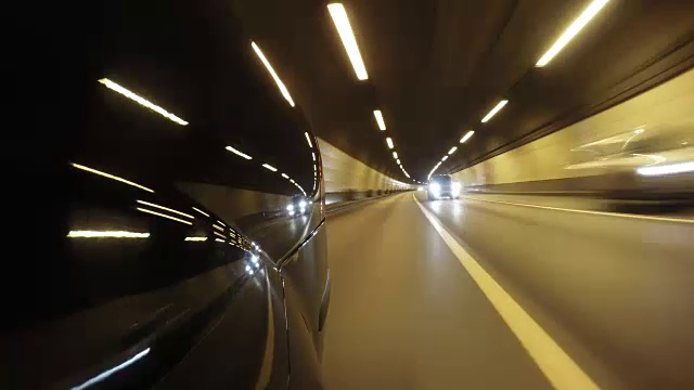 快速城市行驶夜间道路隧道POV时间推移左侧汽车。低角度后视图视频素材
