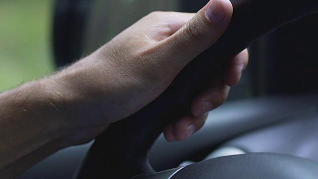 驾驶员的手放在方向盘上，人缓慢地控制着车辆，行驶视频素材