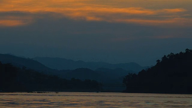 美丽的日落和戏剧性的天空在湖与山脉为背景的泰国。视频下载