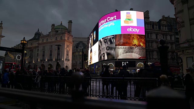 在伦敦皮卡迪利广场明亮的灯光前，车流和行人经过时留下的痕迹视频下载