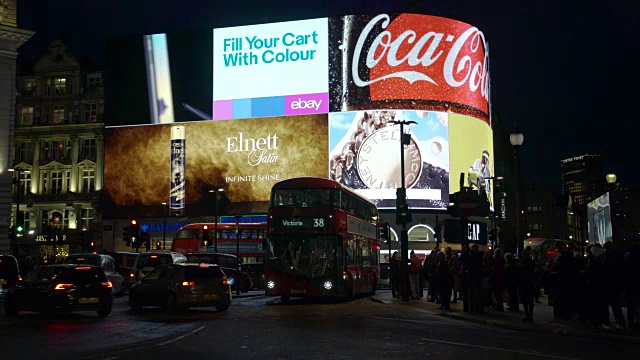 交通和行人从伦敦皮卡迪利广场明亮的灯光前经过视频下载