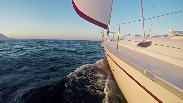 风力驱动的帆船驶向地平线上遥远的岛屿视频素材
