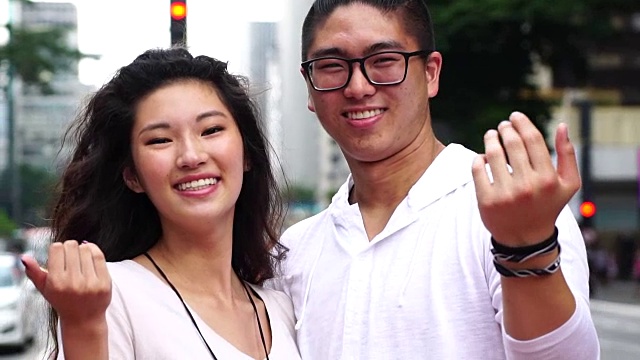 年轻的亚洲夫妇邀请别人来视频素材