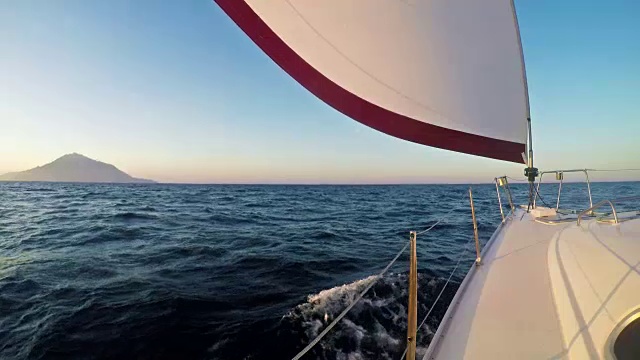 风力驱动的帆船驶向地平线上遥远的岛屿视频素材