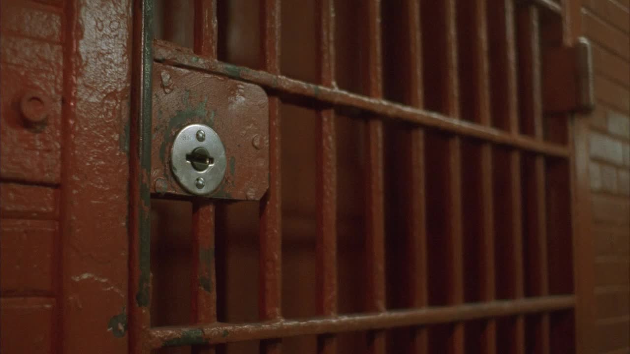 CU，狱警打开牢房门，一名男性囚犯离开(中间部分)视频素材
