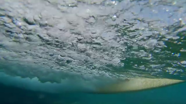 慢动作，低角度:欢快的年轻冲浪运动员骑在可怕的波浪在Lobos视频素材