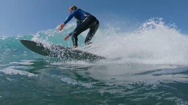 慢动作近景冲浪者在雕刻波浪时将水溅进相机视频素材