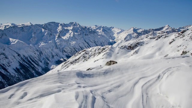 阳光明媚的冬日在雪山阿尔卑斯山脉在索尔登山谷时间流逝。在雪堆上拍摄的多莉视频素材