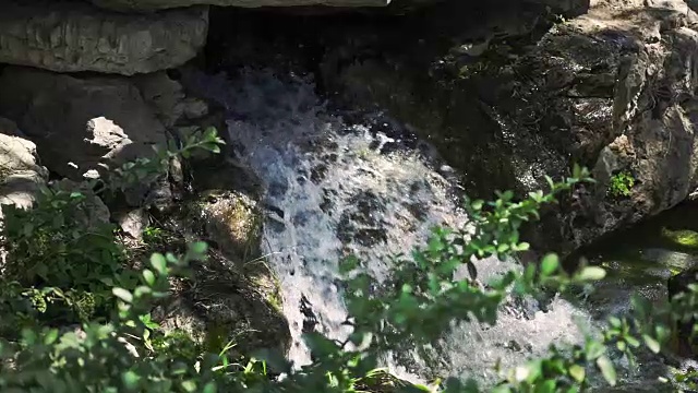 森林深处的瀑布。巨石间天然瀑布的慢镜头视频下载