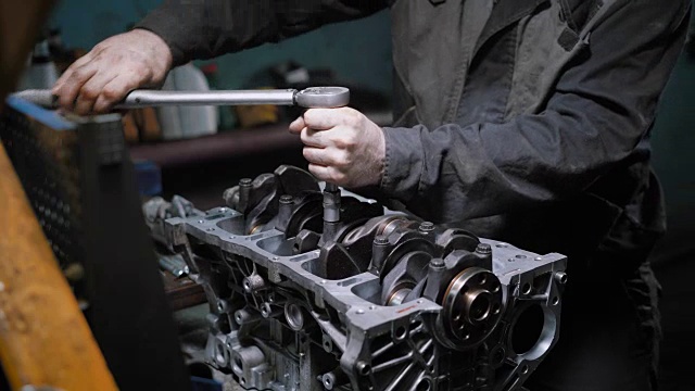 汽车技师是拧紧螺栓上的活塞组在汽车发动机修理后，在一个汽车服务视频素材