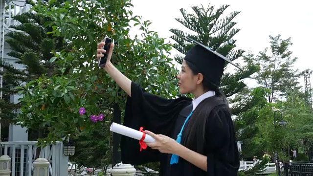 29、大学毕业快乐拿着文凭，用手机自拍视频下载