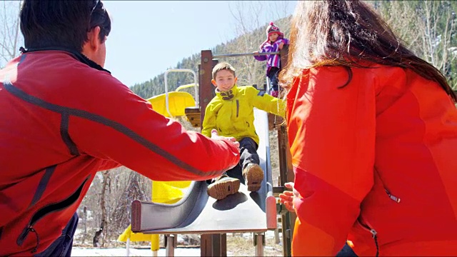 快乐的白种人父母孩子玩户外冬季操场视频下载