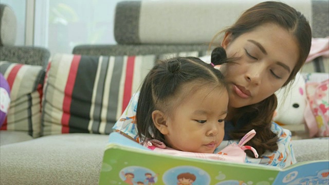 亚洲宝宝和妈妈一起玩和看书视频素材