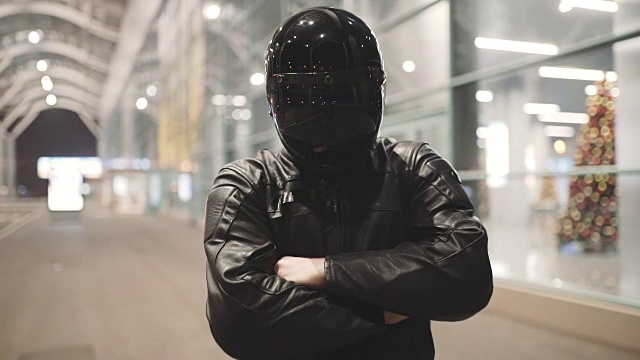 年轻有吸引力的男子摩托车与他的头盔和定制的摩托车在夜间街道视频下载