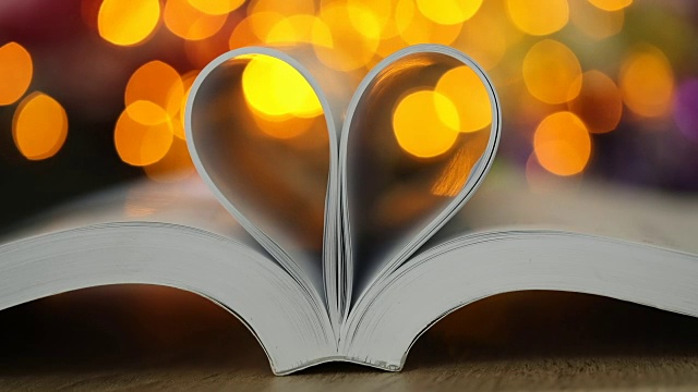 书页装饰成心形与庆祝散景灯为爱情和浪漫情人节概念，4K Dci分辨率视频下载