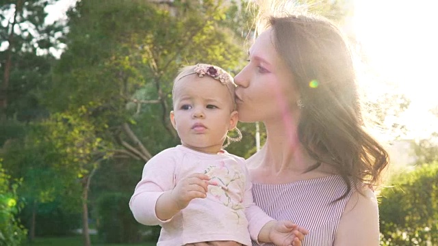 小女孩和漂亮的妈妈在户外拥抱的慢镜头视频素材