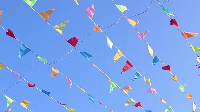 在风中飘扬的三角旗与可爱的固体蓝天背景。视频下载