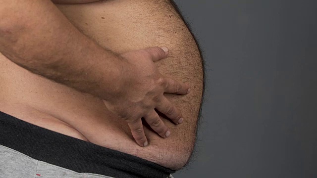肥胖肥胖男性以大肚子为背景，以灰色为主，饮食观念，保健视频素材