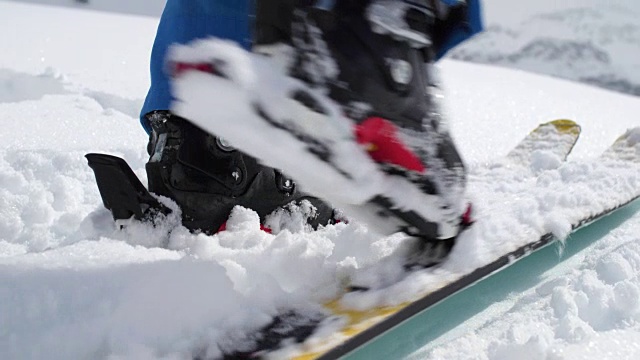 靴子沿着雪景行走的细节。登山滑雪活动。冬季滑雪者在高山户外运动。慢动作60p 4k视频视频下载