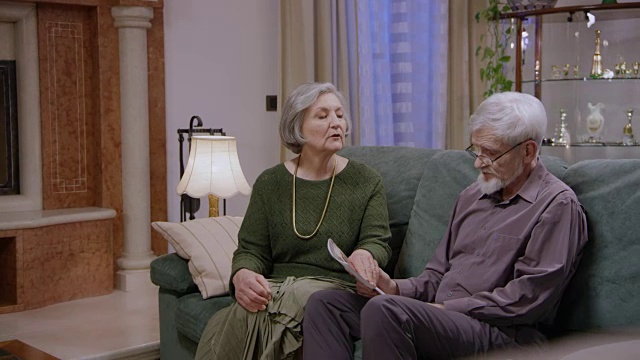 肥皂剧:一位年长的女士坐在她丈夫旁边，试图让他从她的角度看问题视频素材