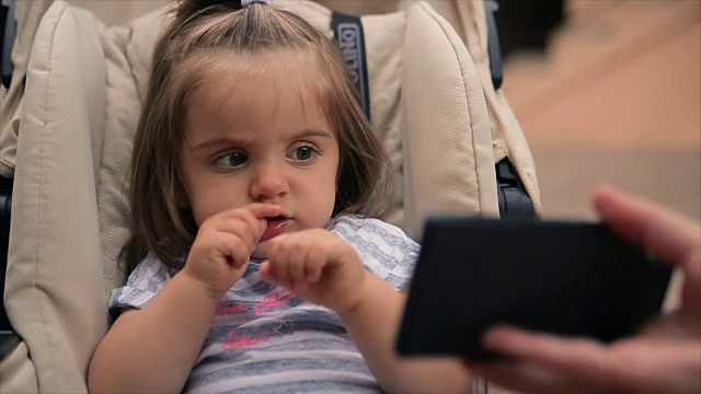 可爱可爱的小女孩看卡通手机视频素材