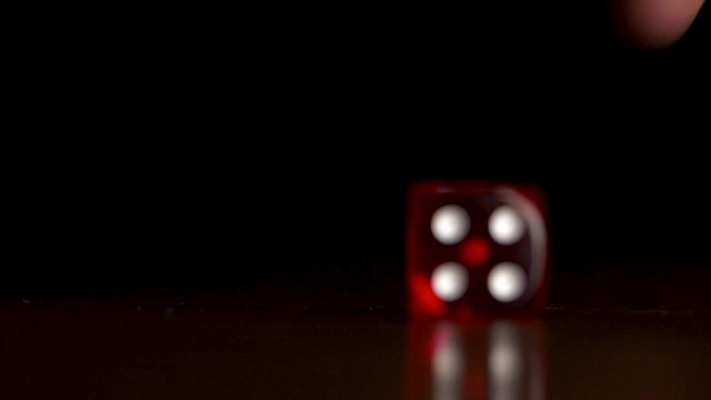 红色骰子落在黑色背景上。赌场的概念。两个人在深色背景的木桌上玩红色的骰子视频下载