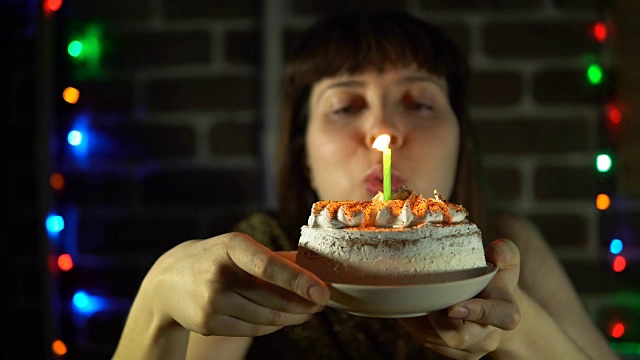 女人吹灭了蛋糕上的蜡烛视频素材