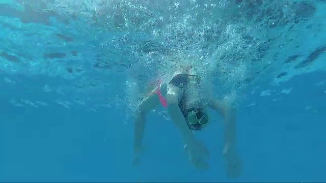 戴面具的女孩在游泳池里绕着身子打转视频下载